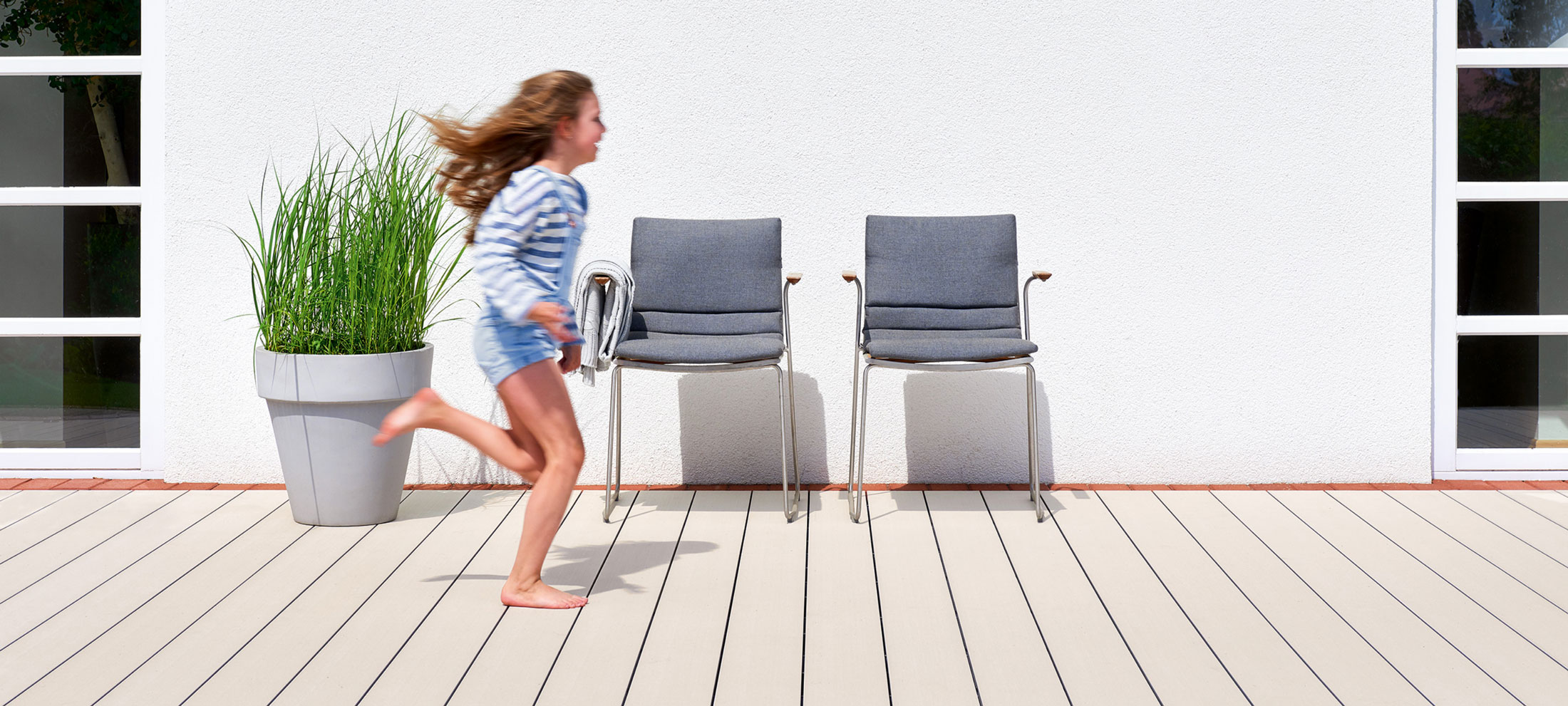 Immagine di una bambina che corre all'esterno di una casa